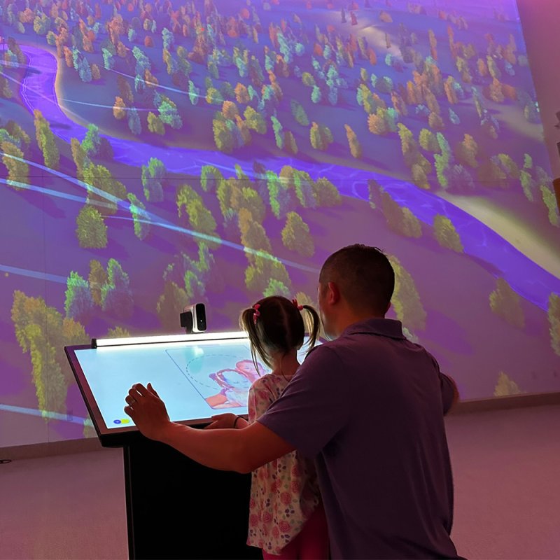 Photo of a father and child experiencing one of the programs in Curiosity Hall