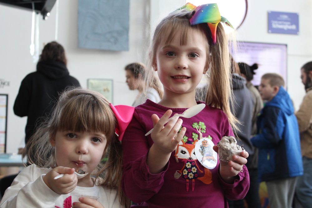 Two young girls taste ice cream during Ice Cream Wars